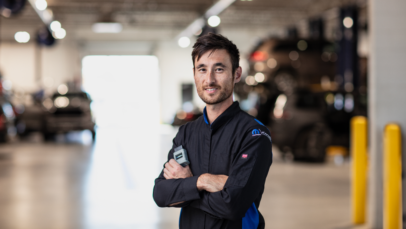 Mopar service technician in front of the entrance to the service bays