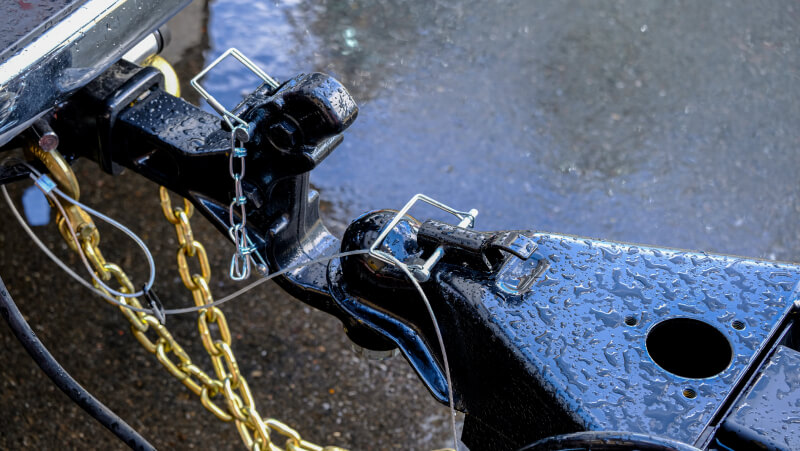Trailer chains crossed under the trailer hitch and connected correctly