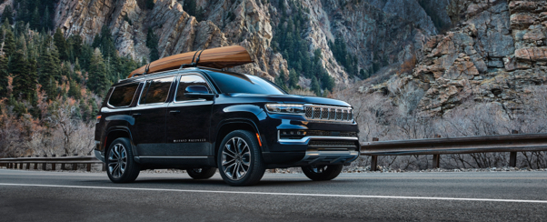 A 2021 Wagoneer carrying a wooden canoe on an available roof rack.