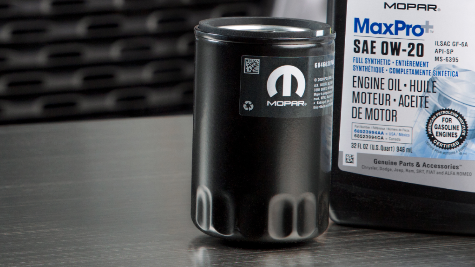 Aceite de motor y filtro Mopar sobre una mesa delante de una camioneta Ram