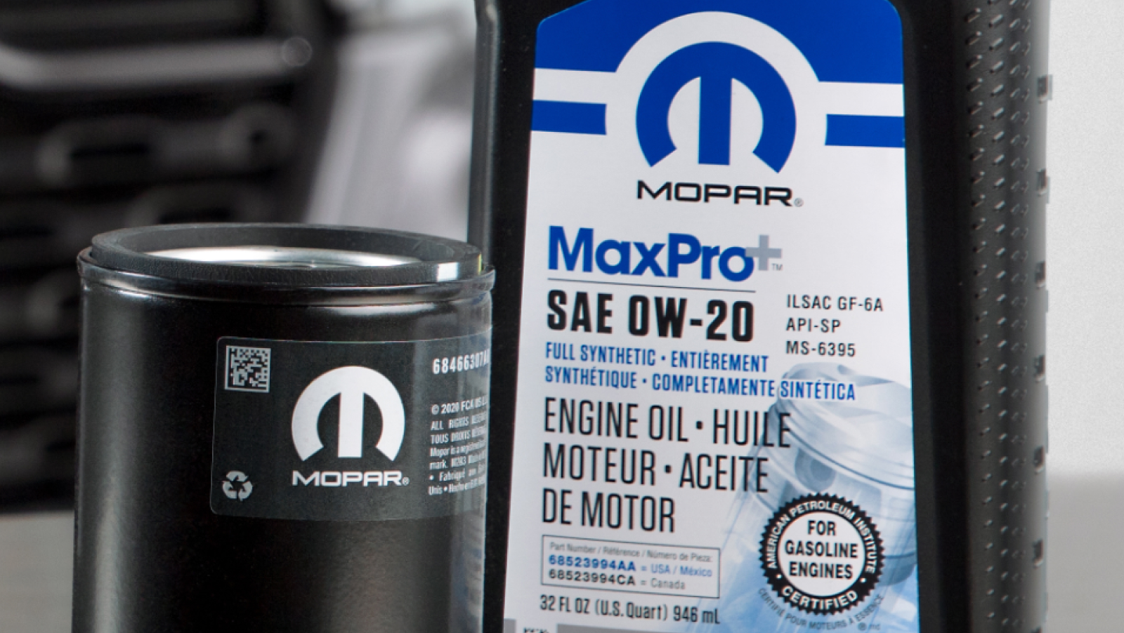 Aceite de motor y filtro Mopar sobre una mesa delante de una camioneta Ram
