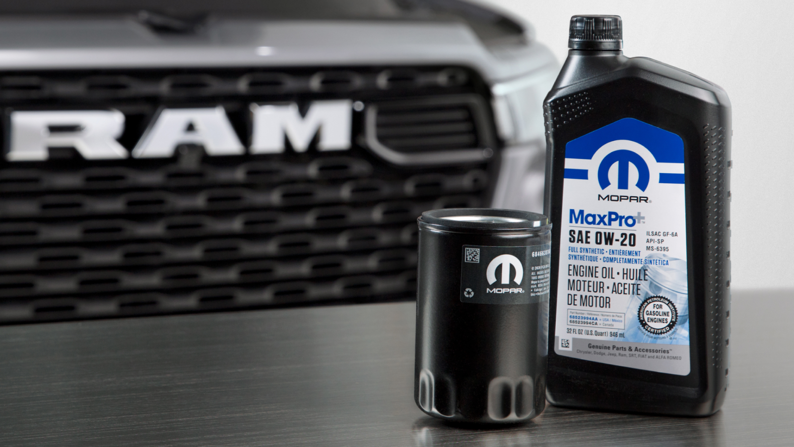 Aceite de motor y filtro Mopar sobre una mesa delante de una camioneta Ram