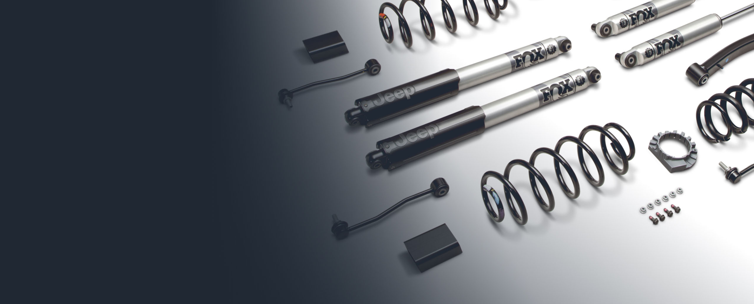 Primer plano de las piezas incluidas en el kit de elevación de 2 pulgadas de Jeep Performance Parts, que incluyen amortiguadores marca Fox.